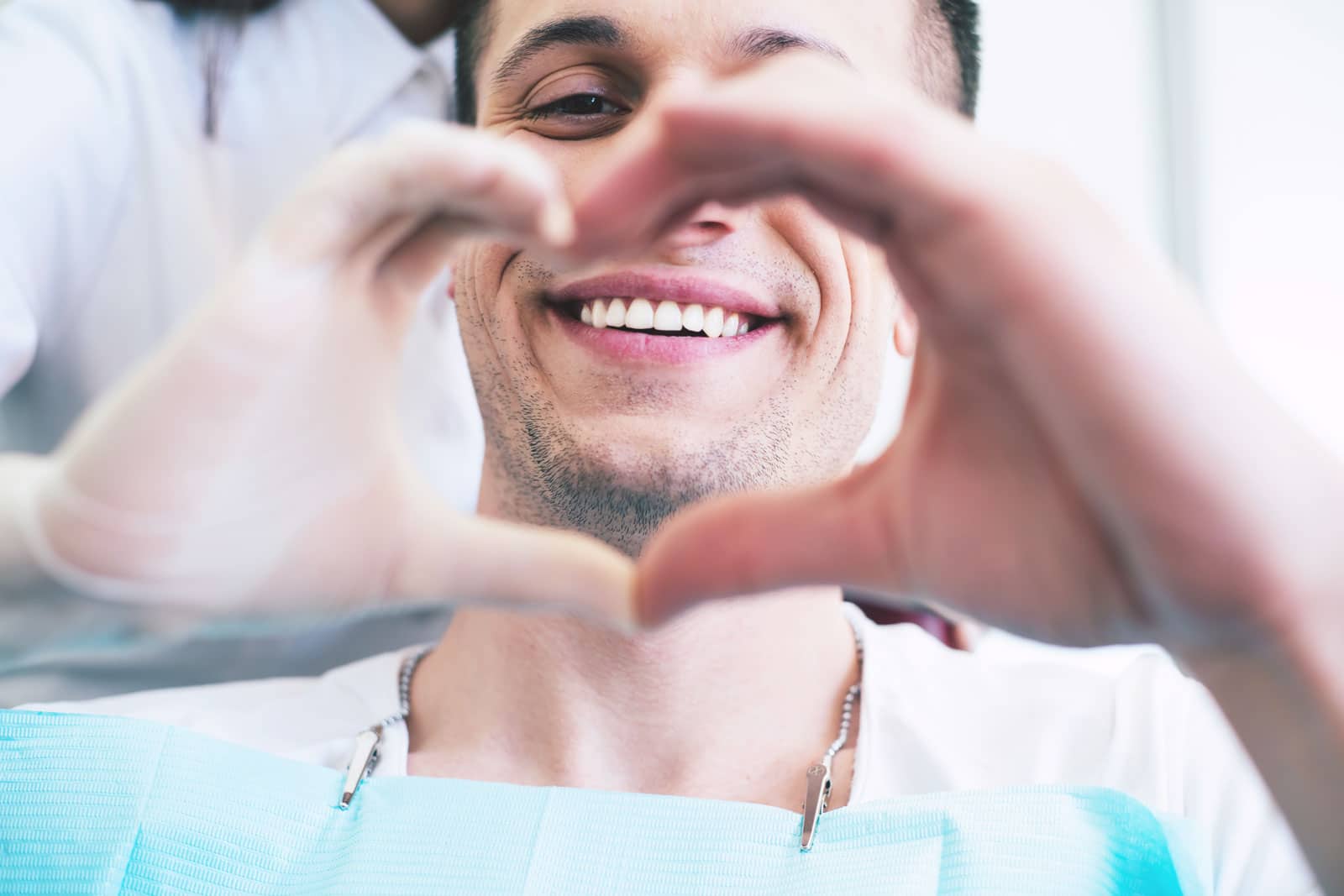 Zahnarztpatient formt Herz mit seinen Händen - Willkommen in der Zahnarztpraxis Gosic & Kollegen - Ihr Zahnarzt in Bochum